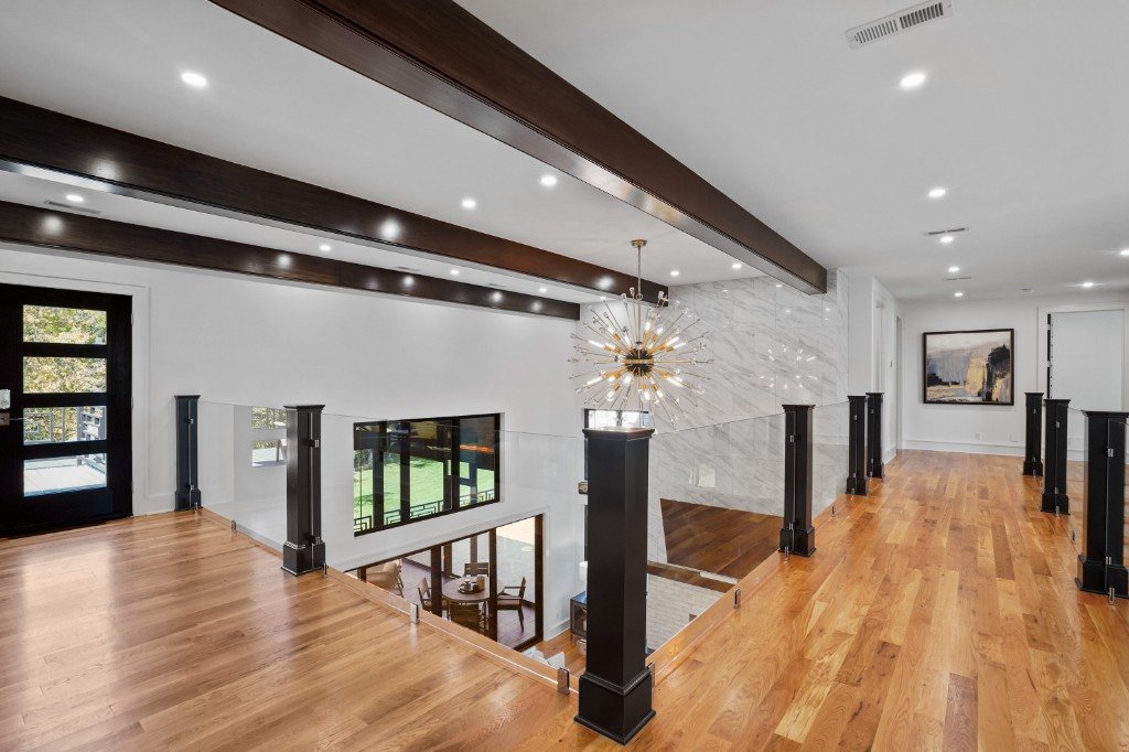 Beamed hallway with marble accent wall and black columns